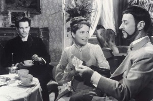 Two men and a woman are in a parlor in a scene in Ingmar Bergman's Smiles of a Summer Night.