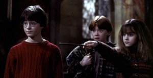Daniel Radcliffe, Rupert Grint, and Emma Watson (holding a wand) star in Harry Potter and the Sorcerer's Stone