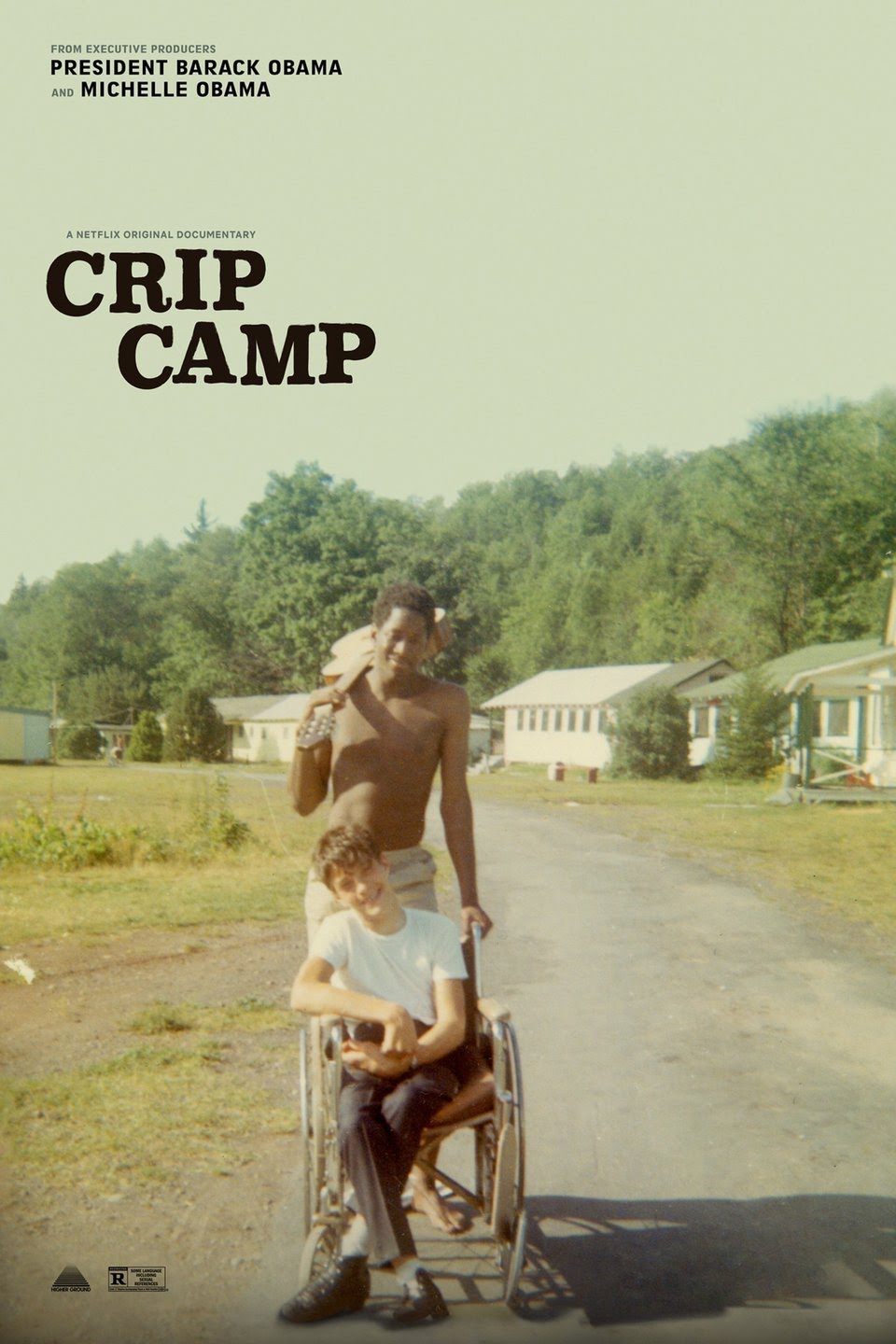 Crip Camp movie poster. A black teen boy poses with a guitar over his shoulder, standing behind a young wheelchair bound white boy in a rural setting.